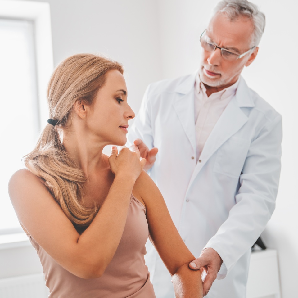 Medical examination on patient shoulder in clinic. Traumatology, orthopedist