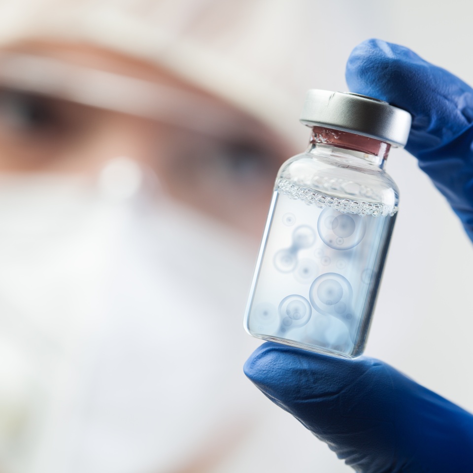 Cell division process conceptual illustration,lab scientist holding ampoule vial with cell nucleus molecules splitting,DNA replication procedure,mitosis daughter from parent chromosome cell production