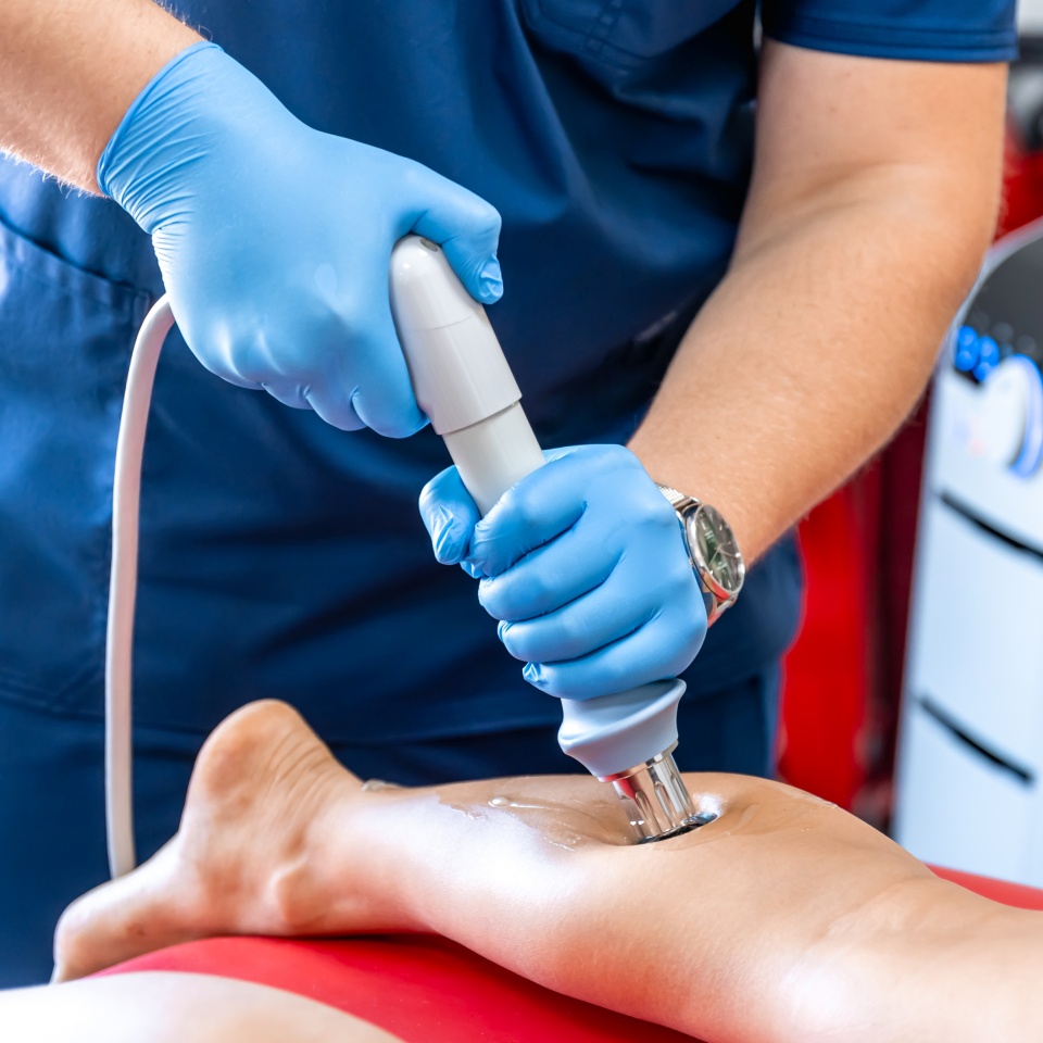 Physical therapy of the shin with shock wave, extracorporeal shockwave therapy.