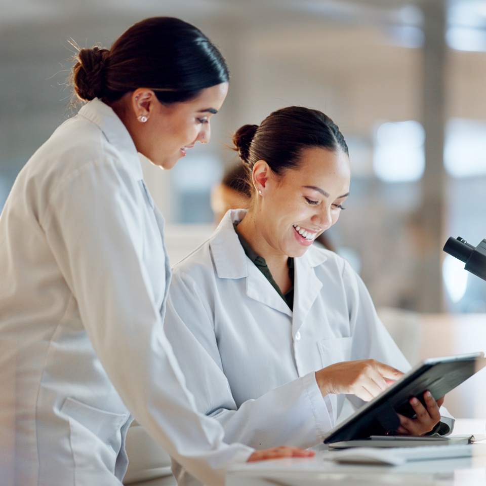 Scientist, women and teamwork on tablet and computer for laboratory advice, medical research and night planning. Students, science people or mentor on digital technology of test results or comparison