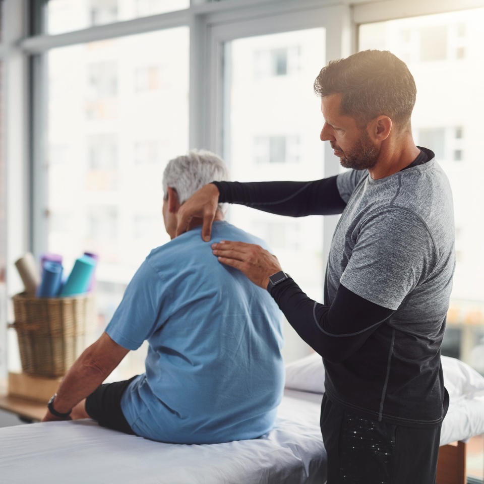 Physiotherapy, shoulder pain and person with senior man for medical care, consulting and wellness. Chiropractor, healthcare and physical therapist and client for rehabilitation, massage or assessment