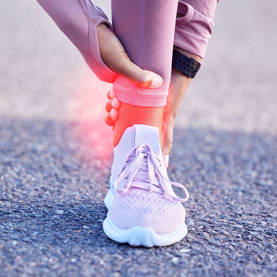 woman holding her aching ankle