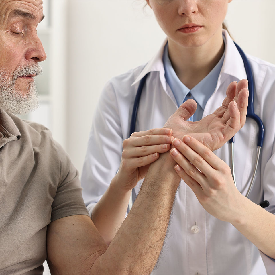 Doctor examining patient's hand in hospital
