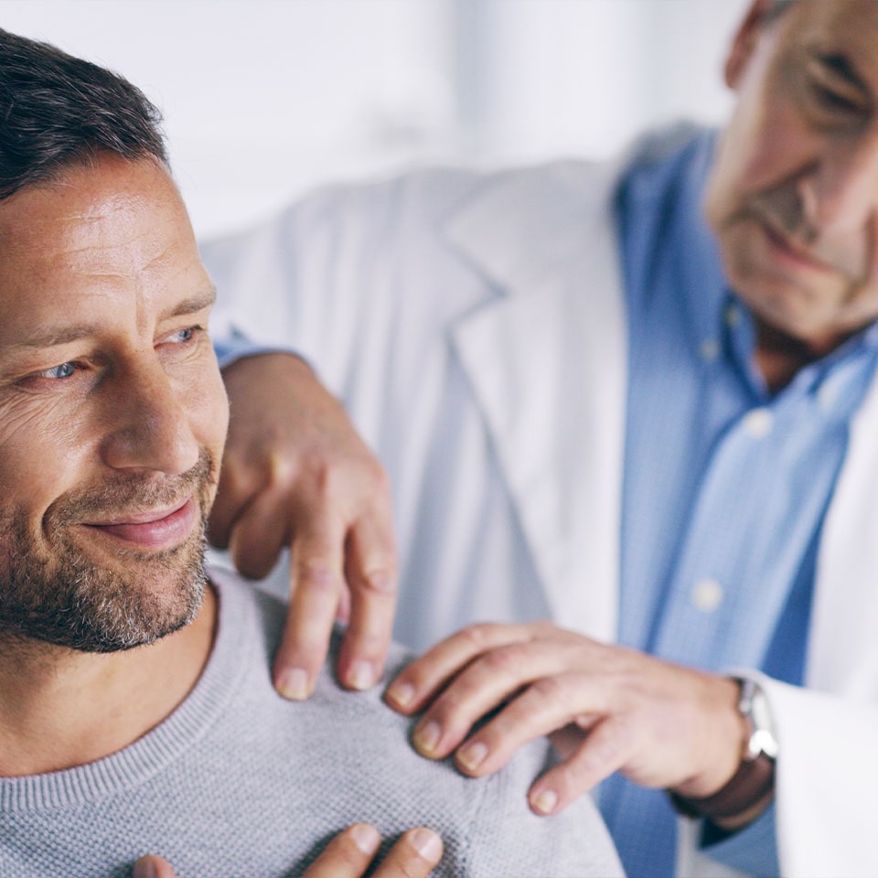 the doctor examines the man's arm